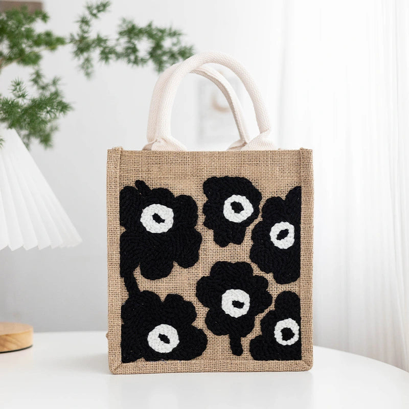 Jute bag with black floral patterns on a white surface
