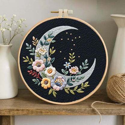 A crescent moon gently cradles blooming flowers, symbolizing peace, hope, and quiet beauty. With soft pastel threads against the dark background, this design captures a dreamy moment — where nature blossoms under the moonlight.