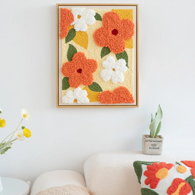 Framed floral artwork on a wall with decorative pillows and plants.