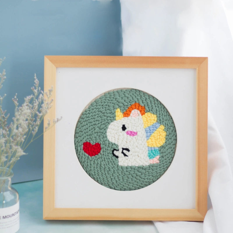 Framed embroidered unicorn with rainbow hair on a light blue background