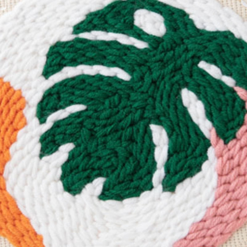 Close-up of a textured fabric with green leaf design on a white background