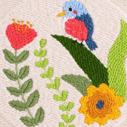 Embroidered design of a bird and flowers on a beige background
