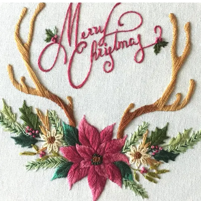 Embroidery design with 'Merry Christmas' text, floral elements, and antlers on a white background.