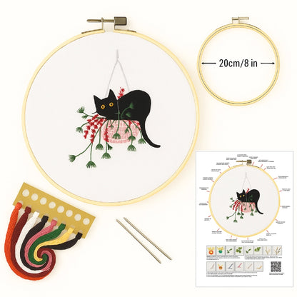 Embroidery kit with hoop, thread, and pattern guide featuring a black cat design.