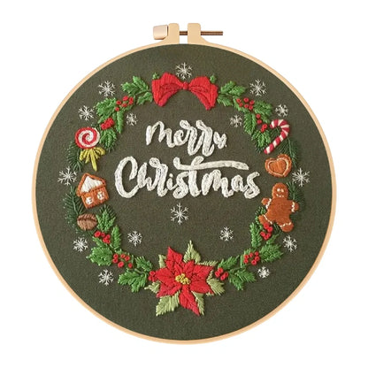 Embroidery hoop with 'Merry Christmas' text and festive decorations on a green background