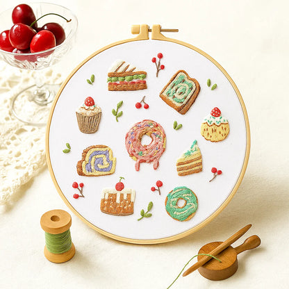 Embroidery hoop with colorful embroidered food patterns on a white background