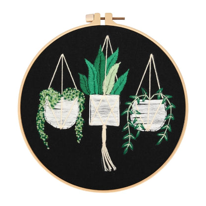 Embroidery hoop with embroidered plants on a black background
