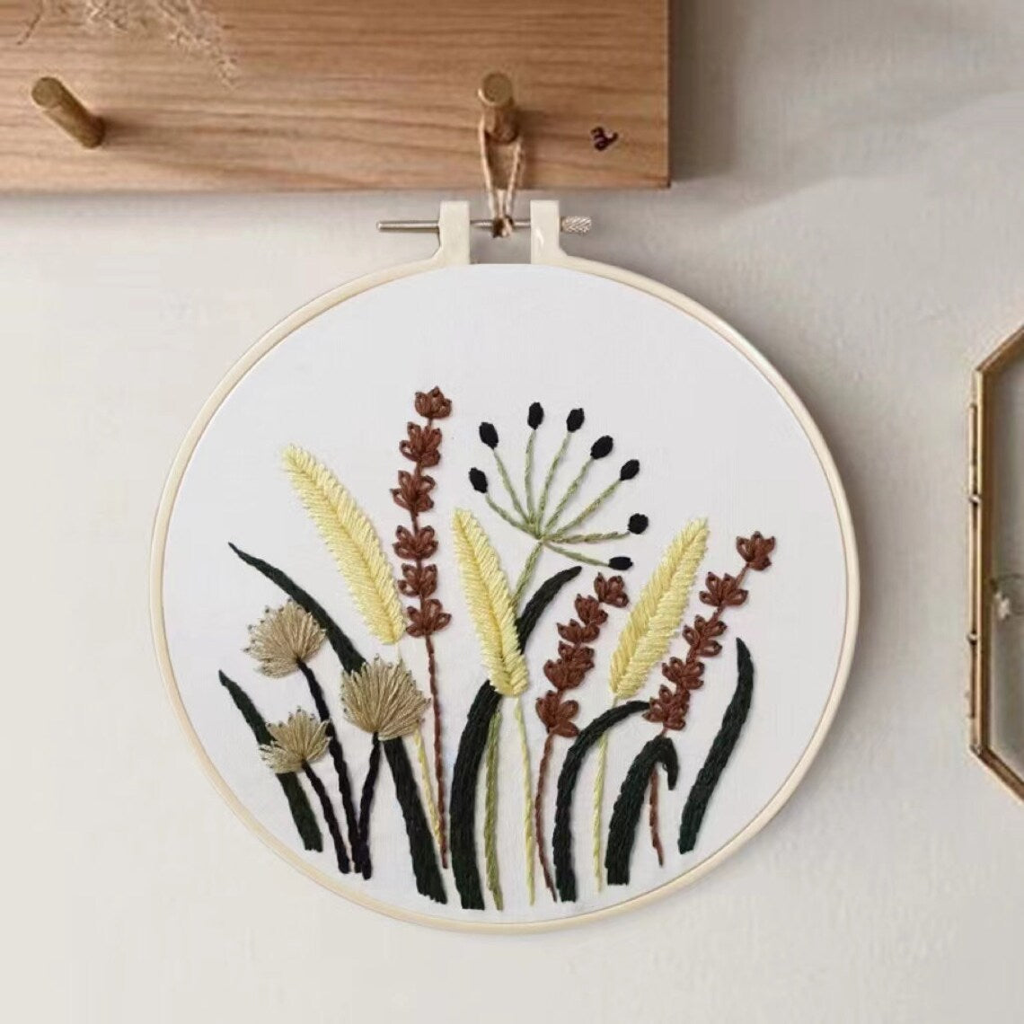 Embroidery hoop with floral design on a white wall