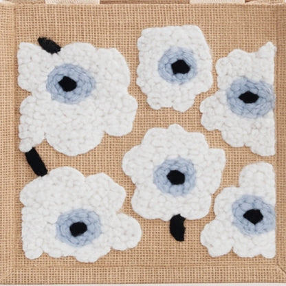 Floral patterns made of white and blue beads on a textured beige background