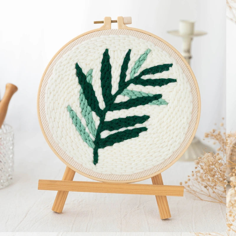 Punch Needle hoop with green leaf design on a white background