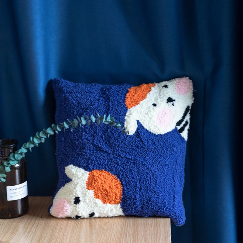 A punch needle pillow featuring two cute cows resting on a deep blue background, full of charm and warmth.