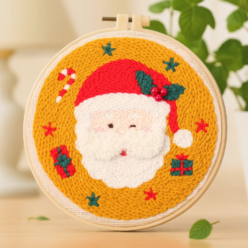 This punch needle artwork features a jolly Santa Claus with a fluffy white beard and a bright red hat adorned with holly leaves and berries. Surrounded by stars, gifts, and candy canes, it perfectly captures the joyful spirit of Christmas — a delightful piece to decorate your home or gift to loved ones.