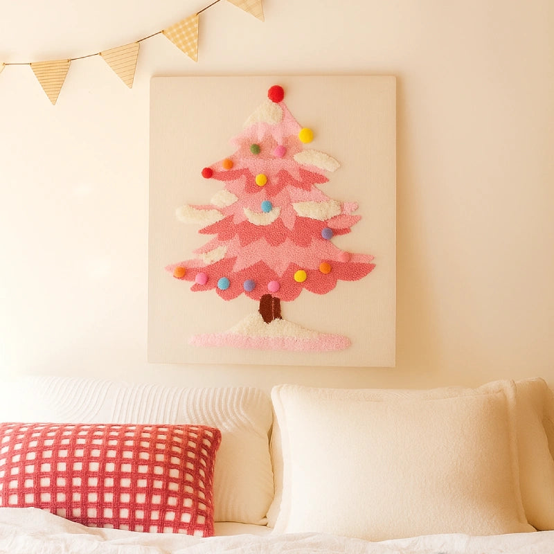 Decorative pink Christmas tree wall art on a beige wall above a bed with pillows.