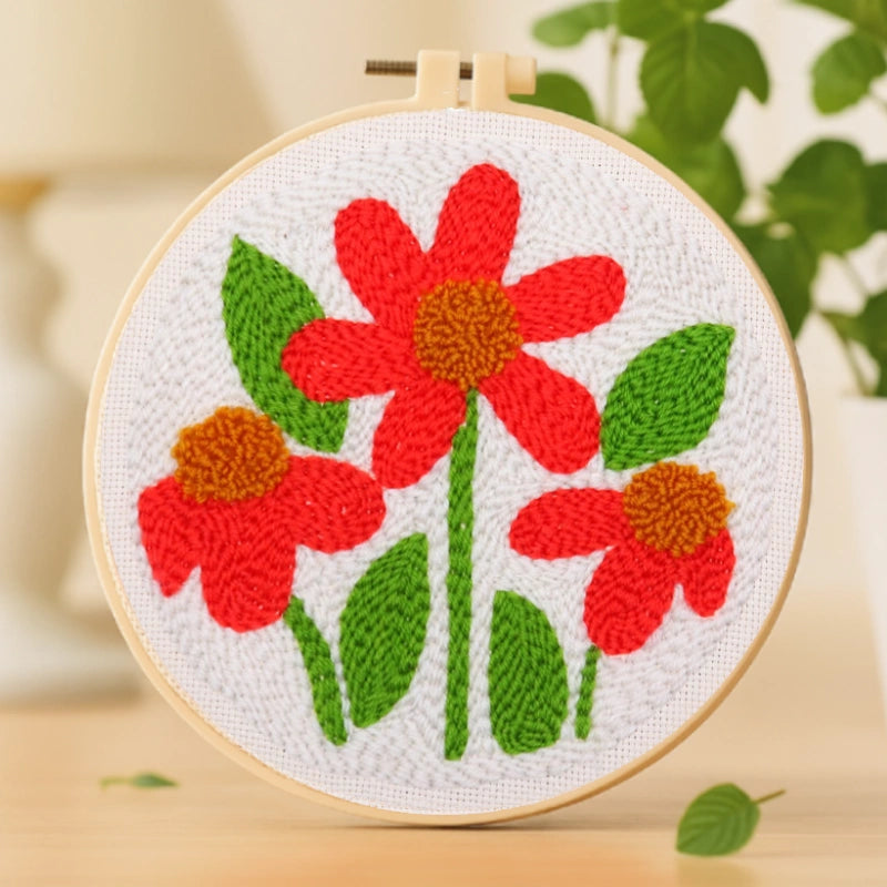 Bright red flowers stand out vividly against lush green leaves, radiating warmth and joy. The simple composition and rich colors bring a lively, cheerful energy to this handmade piece.