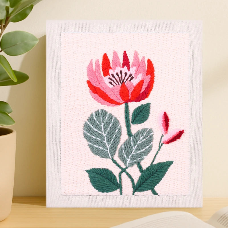 This design features a vibrant red and pink flower with layered petals, accented by deep green leaves and a soft pink background, creating a fresh and elegant look.