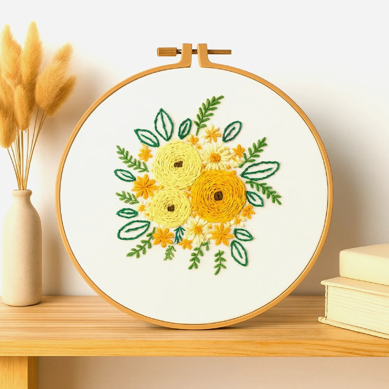 A radiant floral embroidery featuring golden-yellow blooms surrounded by fresh green leaves and delicate blossoms. The design captures the warmth of sunlight in a blooming garden, adding a touch of cheer and natural beauty to any space.