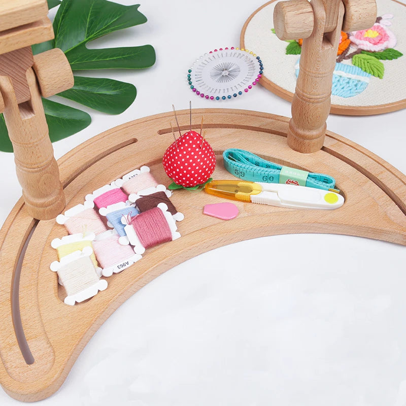 Wooden embroidery hoop with thread and tools on a white background