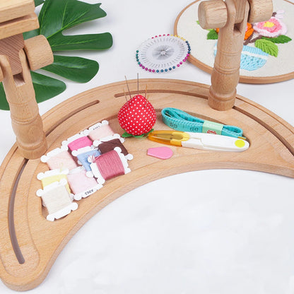 Wooden embroidery hoop with thread and tools on a white background