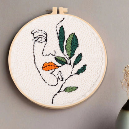 A minimalist face entwined with green leaves and orange lips, whispering softly to nature.