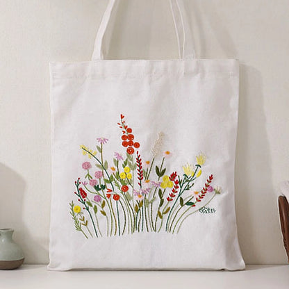 White tote bag with floral embroidery on a neutral background