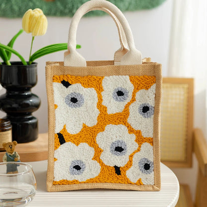 Jute bag with floral pattern on a table with a plant in the background